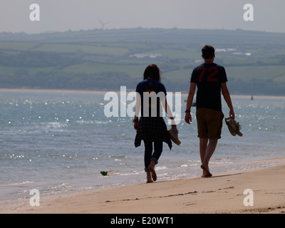 Junges Paar barfuß entlang dem Strand, Padstow, Cornwall, UK Stockfoto