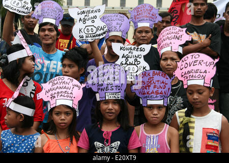 Manila, Philippinen. 12. Juni 2014. Kinder tragen Parolen gegen Korruption und den Schweinefleisch-Lauf als Kopfschmuck in Lawton, Manila. Mehrere hundert Demonstranten verschiedene Protestkundgebungen aller Metro Manila markieren den Philippinen 116. Independence Day statt. Verschiedene Gruppen gefordert, Rechenschaftspflicht und Transparenz in Bezug auf die Korruptionsskandale der hohen Regierungsbeamten ranking. Die Demonstranten forderte auch die Absetzung von Präsident Aquino für seine angebliche Unfähigkeit seiner Verwaltung zu regieren. Bildnachweis: Pazifische Presse/Alamy Live-Nachrichten Stockfoto
