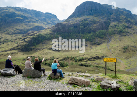 Vier Frauen auf der Suche nach Ansicht von Glen Coe Pass layby zu Gearr Aonach Ridge in Bidean nam Bian Bergmassiv. Glencoe Lochaber Highland Schottland Großbritannien Stockfoto
