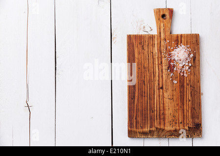 Rosa Salz auf Küche Schneidbrett auf weißem Holz Textur Hintergrund Stockfoto