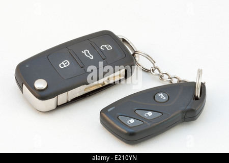 Moderne Autoschlüssel und Fernbedienung vor weißem Hintergrund Stockfoto