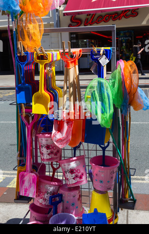 Bunte Eimer, Spaten, Wasserbälle, Fischernetze und Süßigkeiten im Outlet in Southport, Merseyside. Stockfoto