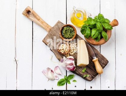 Zutaten für die Zubereitung von Pesto im Mörser auf weißem Holz Hintergrund Stockfoto