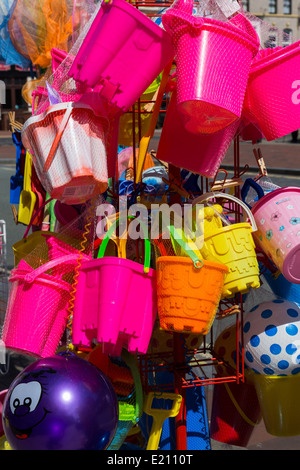 Bunte Eimer, Spaten, Wasserbälle, Fischernetze und Süßigkeiten im Outlet in Southport, Merseyside. Stockfoto