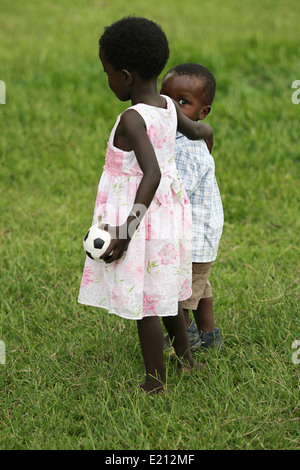 Ein junges Mädchen und sogar jüngeren Knaben, die beiden Waisenkinder tröstet einander Stockfoto