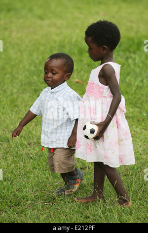 Spielen Sie ein junges Mädchen und sogar jüngeren Knaben, die beiden Waisenkinder zusammen Stockfoto