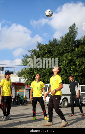 Gaza-Stadt, Gazastreifen, Palästinensische Gebiete. 12. Juni 2014. An einem Fußballspiel teilnehmen während einer Protestaktion gegen die israelische Blockade auf Gaza-Streifen, in Gaza-Stadt am 12. Juni 2014 palästinensische Jugendlichen. Palästinenser Teilen 1 Milliarde oder mehr Menschen auf der ganzen Welt das Gefühl der Vorfreude und Spannung im Moment des Öffnens Anpfiff der WM, wie sie mehr Mühe stürzte, als es der Wasserversorgung, eine Lebensmittelkrise fehlt und steigenden Arbeitslosigkeit aufgrund jahrelanger Israels Blockade der Küste Enklave Credit: Ezz Zanoun/APA Images/ZUMAPRESS.com/Alamy Live News Stockfoto