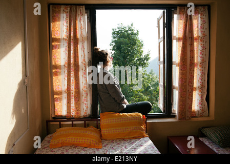 Frau sitzt in einem Fenster Aussicht Stockfoto