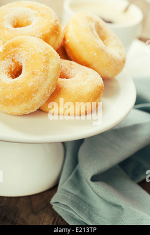 Kaffeepause mit frischem zuckerhaltige Donuts auf weißem Hintergrund Stockfoto