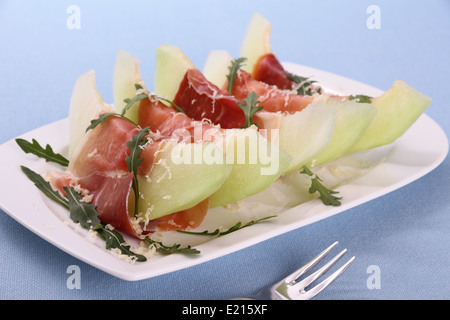 Reife Melone mit Schinken, Parmesan auf weißen Teller, Nahaufnahme Stockfoto