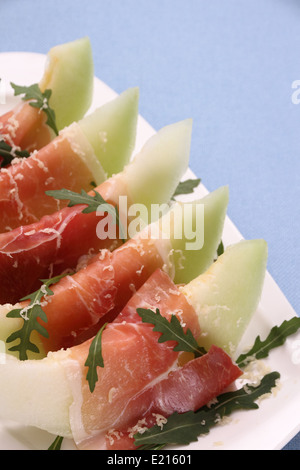 Reife Melone mit Schinken, Parmesan auf weißen Teller, Ansicht von oben Stockfoto