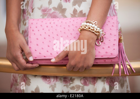 Ein Damen-Hände halten eine rosa Leder-Clutch-Tasche Stockfoto