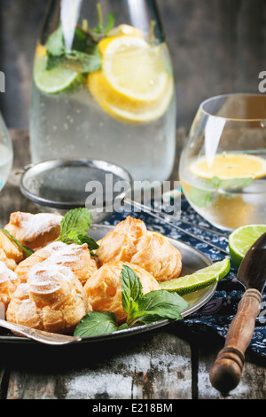 Vintage Teller mit hausgemachten Kuchen Windbeutel mit Limonade auf alten Holztisch serviert Stockfoto