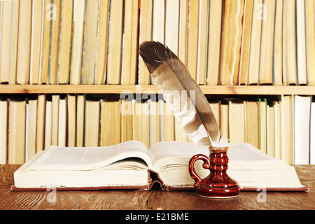 Quill im Tintenfaß auf einem Hintergrund von Büchern Stockfoto