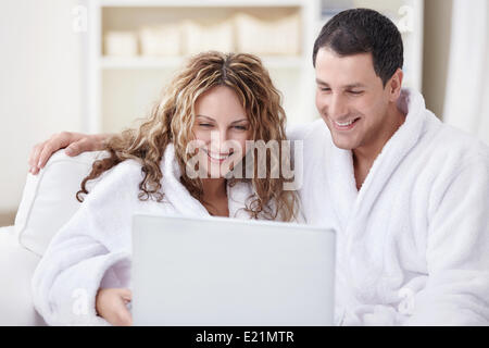 Junges Paar im Overall Blick auf laptop Stockfoto