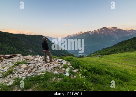 Männliche Wanderer nehmen Rest und vor Sonnenaufgang in der italienisch - französischen Alpen auf Graslandschaft Overlookign ins Tal. Stockfoto