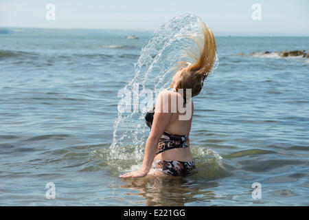 Aberystwyth Wales UK Freitag, 13. Juni 2014 Aberystwyth Wales UK mit Temperaturen voraussichtlich bis Mitte 20 Celsius eine junge Frau, Ebenholz Fennell, 22, findet Relief aus dem heißen Wetter im Meer in Aberystwyth an der Westküste von Wales klettern. Bildnachweis: Keith Morris/Alamy Live-Nachrichten Stockfoto