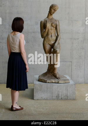 Duisburg, Deutschland. 13. Juni 2014. Ein Mitarbeiter befasst sich mit der Skulptur "Kniend" (lit. / 1911) durch Wilhelm Lehmbruck in der reparierten Flügel des Lehmbruck Museums in Duisburg, Deutschland, 13. Juni 2014. Der neue Flügel zeigt die Rekonstruktion der Ausstellung mit Werken von dem Bildhauer Wilhelm Lehmbruck, wie sie bei der Eröffnung des Museums im Jahre 1964 präsentiert wurden. © Dpa picture-Alliance/Alamy Live News Stockfoto