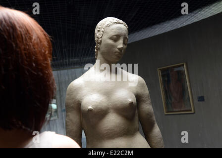 Duisburg, Deutschland. 13. Juni 2014. Ein Mitarbeiter befasst sich mit der Skulptur "Stehende weibliche Figur" (lit. / 1910) durch Wilhelm Lehmbruck in der reparierten Flügel des Lehmbruck Museums in Duisburg, Deutschland, 13. Juni 2014. Der neue Flügel zeigt die Rekonstruktion der Ausstellung mit Werken von dem Bildhauer Wilhelm Lehmbruck, wie sie bei der Eröffnung des Museums im Jahre 1964 präsentiert wurden. © Dpa picture-Alliance/Alamy Live News Stockfoto