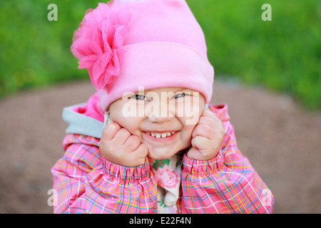 Lustig Lachen kaukasischen Babymädchen in rosa, outdoor portrait Stockfoto