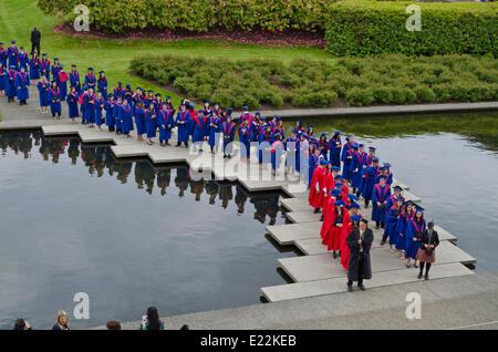 Simon Fraser University Diplomanden durch die reflektierende Teich in der Akademischen Viereck vor dem Frühjahr Einberufung Zeremonie 2014 für die Fakultät für Geistes- und Sozialwissenschaften. Credit: Maria Janicki/Alamy Stockfoto