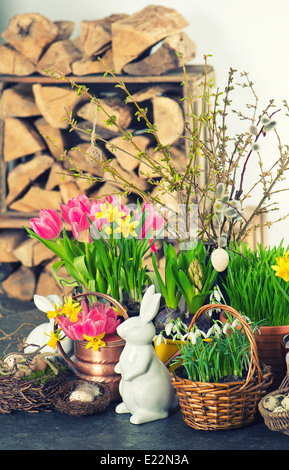 Oster-Deko mit Hasen, Eiern und Frühling Blumen. Tulpen, Schneeglöckchen und Narzissen-Blüten. selektiven Fokus Stockfoto