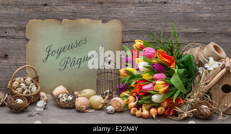 Oster-Deko mit Eiern und Tulpe Blumen. Vintage-Stil-Stillleben mit Beispieltext Frohe Ostern! AUF FRANZÖSISCH Stockfoto
