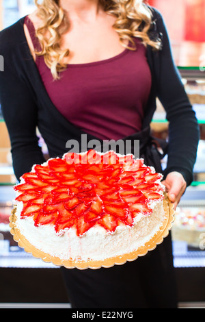 Weibliche Konditor präsentiert Tablett mit Kuchen in der Bäckerei oder Konditorei Stockfoto