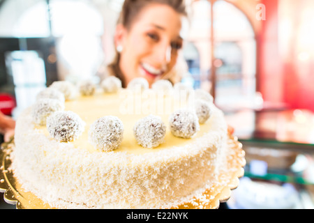 Weibliche Konditor präsentiert Tablett mit Kuchen in der Bäckerei oder Konditorei Stockfoto