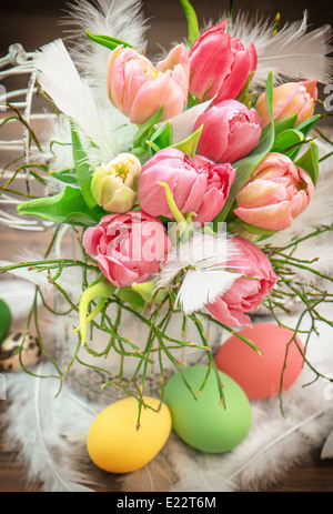 Oster-Deko mit rosa Tulpe Blumen und bemalten Eiern. leuchtende Farben Stockfoto