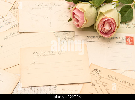 alte Ansichtskarten und weiche Rosenblüten. alten Liebesbriefe. romantisches Stilleben Stockfoto