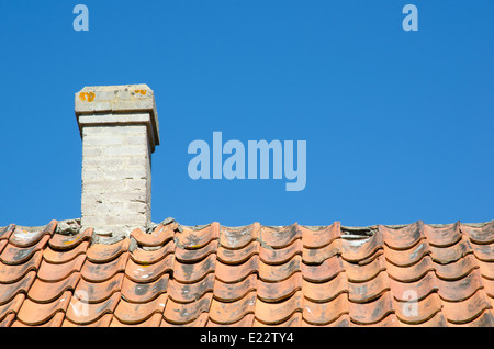 Schornstein bei einer alten gebrochenen Ziegeldach am blauen Himmel Stockfoto