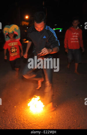 Solo, Indonesien. 14. Juni 2014. SOLO, JAVA, Indonesien - Juni 12: Indonesische Männer spielen Fußball Feuer. Â beim warten auf der Eröffnung der FIFA Fussball-Weltmeisterschaft 2014 in Brasilien, in Solo, Java, Indonesien, am 12. Juni. Feuer-Fußball ist ein Fußballspiel mit einen Feuerball der Kokosnuss getränkt von Kerosin in Brand. © Agoes Rudianto/NurPhoto/ZUMAPRESS.com/Alamy Live-Nachrichten Stockfoto