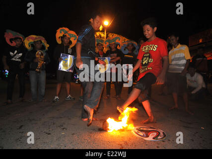 Solo, Indonesien. 14. Juni 2014. SOLO, JAVA, Indonesien - Juni 12: Indonesische Männer spielen Fußball Feuer. Â beim warten auf der Eröffnung der FIFA Fussball-Weltmeisterschaft 2014 in Brasilien, in Solo, Java, Indonesien, am 12. Juni. Feuer-Fußball ist ein Fußballspiel mit einen Feuerball der Kokosnuss getränkt von Kerosin in Brand. © Agoes Rudianto/NurPhoto/ZUMAPRESS.com/Alamy Live-Nachrichten Stockfoto