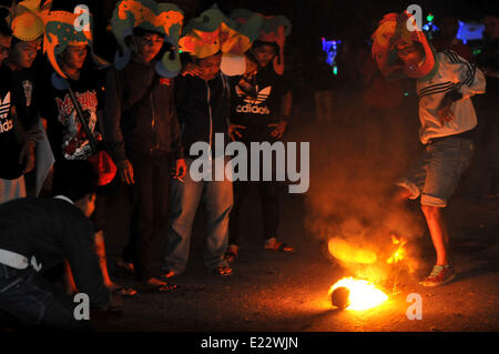 Solo, Indonesien. 14. Juni 2014. SOLO, JAVA, Indonesien - Juni 12: Indonesische Männer spielen Fußball Feuer. Â beim warten auf der Eröffnung der FIFA Fussball-Weltmeisterschaft 2014 in Brasilien, in Solo, Java, Indonesien, am 12. Juni. Feuer-Fußball ist ein Fußballspiel mit einen Feuerball der Kokosnuss getränkt von Kerosin in Brand. © Agoes Rudianto/NurPhoto/ZUMAPRESS.com/Alamy Live-Nachrichten Stockfoto