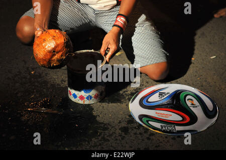 Solo, Indonesien. 14. Juni 2014. SOLO, JAVA, Indonesien - Juni 12: Indonesische Mann spielen Fußball Feuer vorbereiten. Â beim warten auf der Eröffnung der FIFA Fussball-Weltmeisterschaft 2014 in Brasilien, in Solo, Java, Indonesien, am 12. Juni. Feuer-Fußball ist ein Fußballspiel mit einen Feuerball der Kokosnuss getränkt von Kerosin in Brand. © Agoes Rudianto/NurPhoto/ZUMAPRESS.com/Alamy Live-Nachrichten Stockfoto