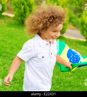 Porträt von niedlichen kleinen Jungen mit Brasilien Nationalflagge, fröhliche junge Fußballspieler, Fan der brasilianischen Fußball-Nationalmannschaft Stockfoto