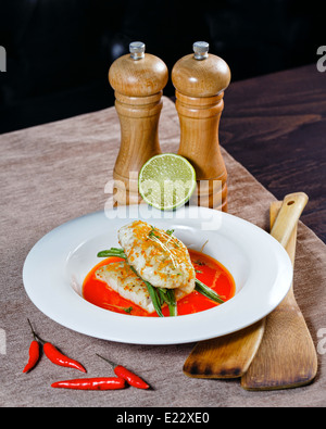 Filet vom Barsch mit Gemüse und Soße serviert auf einem weißen Teller in einem restaurant Stockfoto