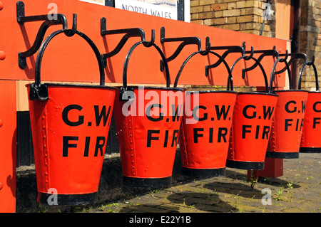 Reihe von roten viktorianischen Feuer Eimer auf dem Bahnsteig, Hampton Loade, Shropshire, England, Vereinigtes Königreich, West-Europa. Stockfoto