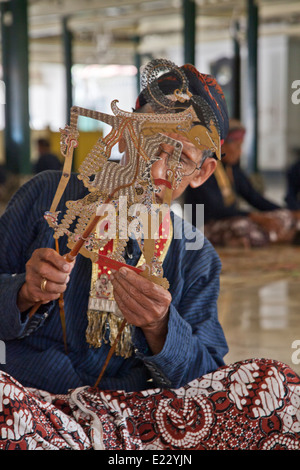 Handwerksmeister inspiziert die traditionellen Leder Puppe vor dem Wayang Kulit Schatten Puppenspiel Show in Yogyakarta, Indonesien Stockfoto