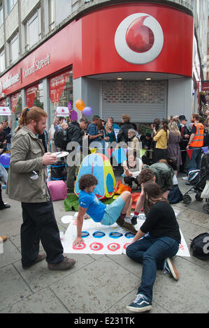 London, UK. 14. Juni 2014. UKUncut Aktivisten protestieren vor dem Vodafone-Shop in der Londoner Oxford Street. Die Demonstranten "Steuer-Dodge Twister" gespielt und musiziert, als andere das Innere des Speichers belegt. Bildnachweis: Pete Maclaine/Alamy Live-Nachrichten Stockfoto