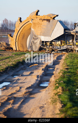 Einen riesigen Schaufelradbagger bei der Arbeit in einer Braunkohle pit mine mit einem Feldweg erkennbar, die im Vordergrund Stockfoto