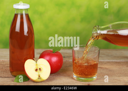 Frischer Apfelsaft ist aus der Flasche in ein Glas gießen. Stockfoto