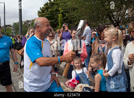 Edinburgh, Schottland. 14. Juni 2014.  Der Königin Baton Relay kommt in Edinburgh mit der Straßenbahn und Michael Laing breitet sich Commonwealth Games Fieber, zeigt auf die Leitung, die die Straßen säumen, bevor es weitergegeben und bahnt sich seinen Weg durch die Straßen der Hauptstadt. Gavin Hastings ehemaliger Schottland Rugby-Kapitän sieht in den Himmel in der Royal Mile. Bildnachweis: Bogen weiß/Alamy Live-Nachrichten Stockfoto