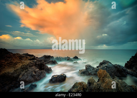 Sunrise und Wolken am felsigen Strand. Maui, Hawaii Stockfoto