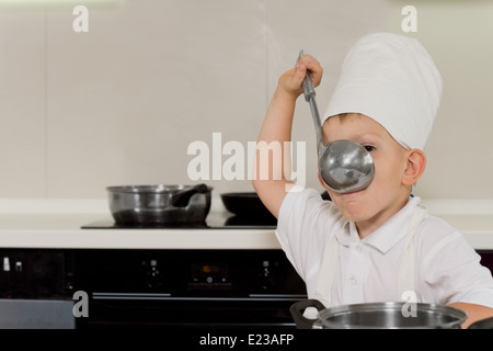 Jungkoch Verkostung Suppe aus Pfanne in der Küche Stockfoto