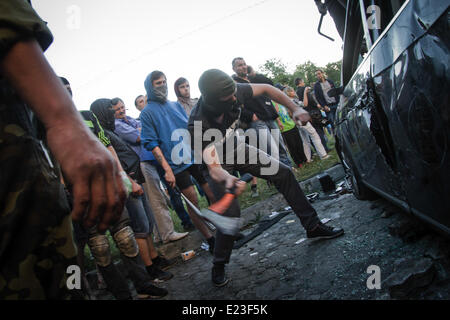 Kiew, Ukraine. 14. Juni 2014. Demonstrant reißt das Fahrzeug der Botschaft der Russischen Föderation mit Axt. Rund 300 Menschen Ansturm auf der russischen Botschaft und umgeworfen und zerstört Mitarbeiter Fahrzeuge, aus Protest gegen den russischen Präsidenten Vladimir Putin nach dem pro-russische Rebellen eine ukrainische militärische Transportflugzeug Samstag abgeschossen alle 49 Soldaten an Bord in der größte einzelne Verlust des Lebens in der zwei-Monats-Aufstand zu töten.  Bildnachweis: Sergii Kharchenko/PACIFIC PRESS/Alamy Live-Nachrichten Stockfoto