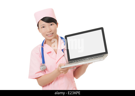 Schöne chinesische Krankenschwester hält einen Laptop-Computer mit einem Beschneidungspfad auf den leeren Bildschirm isoliert auf weißem Hintergrund Stockfoto