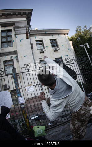 Kiew, Ukraine. 14. Juni 2014. Demonstrant wirft die leere Flasche in Richtung der Botschaft der Russischen Föderation. Die Vereinigten Staaten verurteilt Angriff auf die russische Botschaft in Kiew am Samstag und fordert Ukraine angemessene Sicherheitsleistung für die diplomatische Mission. Die US-Reaktion kam nach einer Menschenmenge, entzündet durch den Abschuss der ukrainischen militärischen Transportflugzeug, rissen die Botschaft Flagge und Fahrzeuge umgeworfen, als ein Dutzend Polizei schaute auf. Sergii Kharchenko/NurPhoto/ZUMAPRESS.com/Alamy © Live-Nachrichten Stockfoto