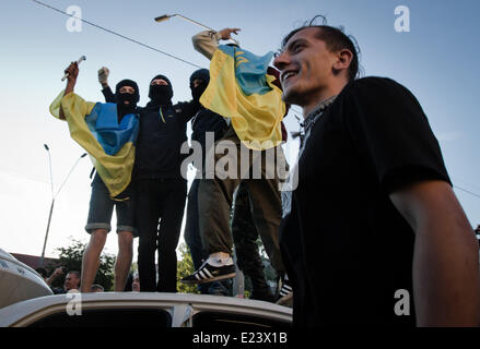 Kiew, Ukraine. 14. Juni 2014. Demonstranten springen auf dem Dach der Botschaft der Russischen Föderation Autos. Die Vereinigten Staaten verurteilt Angriff auf die russische Botschaft in Kiew am Samstag und fordert Ukraine angemessene Sicherheitsleistung für die diplomatische Mission. Die US-Reaktion kam nach einer Menschenmenge, entzündet durch den Abschuss der ukrainischen militärischen Transportflugzeug, rissen die Botschaft Flagge und Fahrzeuge umgeworfen, als ein Dutzend Polizei schaute auf. Sergii Kharchenko/NurPhoto/ZUMAPRESS.com/Alamy © Live-Nachrichten Stockfoto